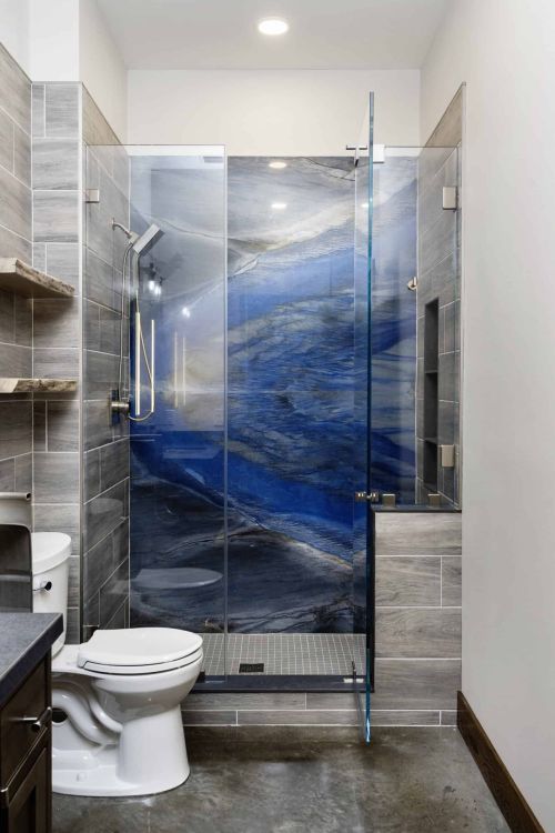 walk-in shower with gray tiles and impressive blue granite wall as seen from entrance to bathroom
