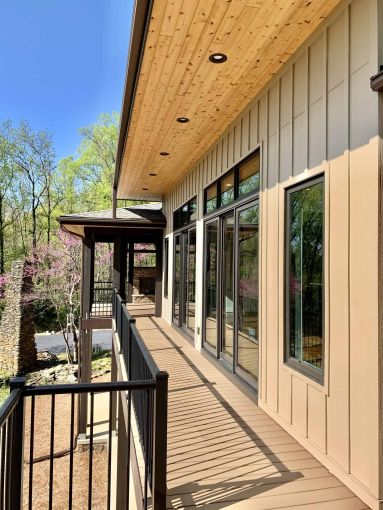 close view of a home balcony with a cedar roof and recessed lighting leading to an outdoor fireplace