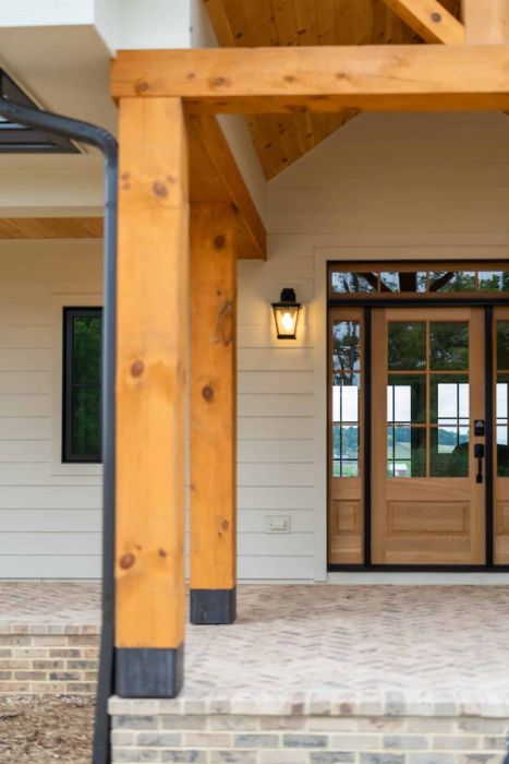 front porch with natural wood beams and stone pavement